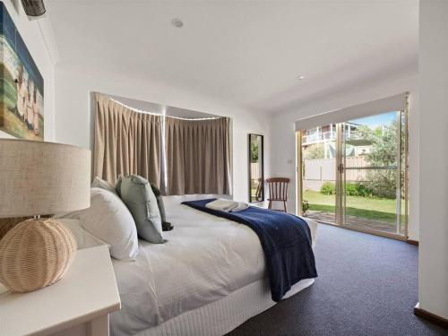 a bedroom with a large bed and a large window at Whale Watch Augusta Family Retreat in Augusta