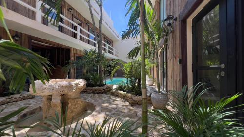 a courtyard of a building with a swimming pool at Harmonia Tulum in Tulum