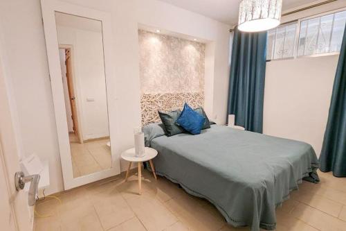 una camera da letto con letto, cuscini blu e specchio di Apartamento Tenerife Sur a Playa de las Americas