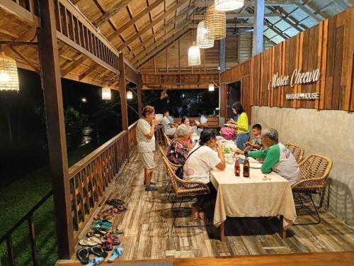 un gruppo di persone seduti ai tavoli in un ristorante di บ้านวารีชีวา WareeCheewa 