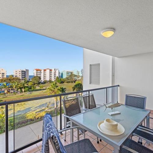 a dining room with a table and chairs and a balcony at The Mirage Resort Alexandra Headland in Alexandra Headland