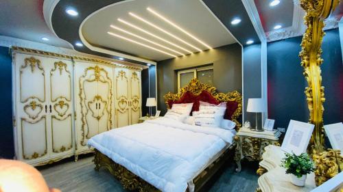 - une chambre avec un grand lit blanc et des orfèvreries dans l'établissement المهندسين البطل احمد عبد العزيز, au Caire