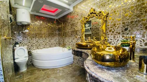 La salle de bains est pourvue d'une baignoire en or et d'un lavabo. dans l'établissement المهندسين البطل احمد عبد العزيز, au Caire