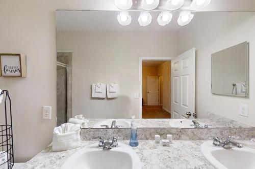 a bathroom with two sinks and a large mirror at Carson Lake Escape in Jacksonville