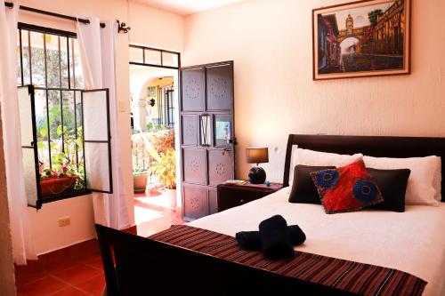 Un dormitorio con una cama con un osito de peluche. en Casa Quetzalli, La Recolección en Antigua Guatemala
