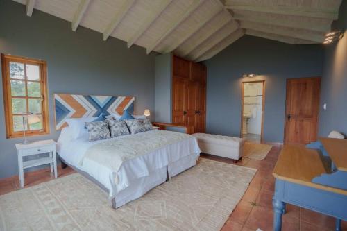 a bedroom with a large bed and a desk at Casa de Lujo frente al Mar en Buchupureo-Curanipe in Curanipe
