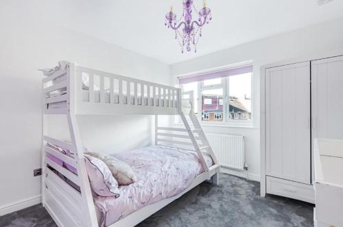 a white bunk bed in a white room with a chandelier at HARTFORDE HOUSE in Borehamwood