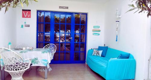 a patio with a blue door and a table and chairs at Ocean & Pool view Puerto del Carmen in Puerto del Carmen