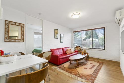 a living room with a red couch and a table at The Newstead in Melbourne