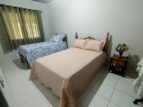 um quarto com uma cama, uma mesa e uma janela em Casa de campo Bela Vista em Itamonte