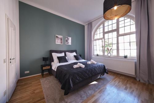 una camera con un letto e una grande finestra di Historisches Deluxe Apartment im Marianum a Neuss