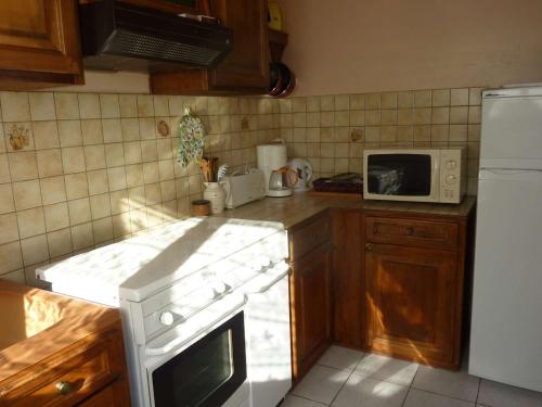 une cuisine avec une cuisinière blanche et un micro-ondes dans l'établissement Maison Calme à Saint-Pierre-d'Oléron, Proche Plage et Commerces, 4 Couchages - FR-1-246A-149, à Saint-Pierre-dʼOléron