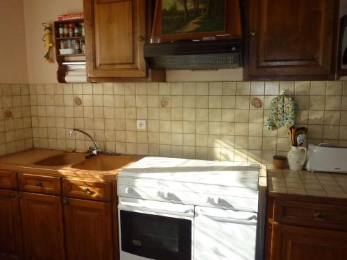 La cuisine est équipée d'un évier et de plaques de cuisson blanches. dans l'établissement Maison Calme à Saint-Pierre-d'Oléron, Proche Plage et Commerces, 4 Couchages - FR-1-246A-149, à Saint-Pierre-dʼOléron