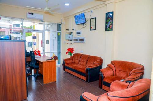 a waiting room with two chairs and a desk at UK Inn Guest House in Jaffna