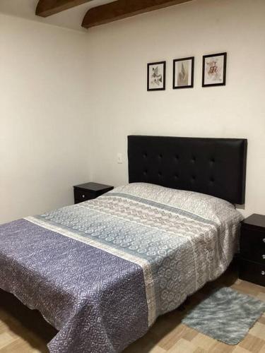 a bedroom with a bed and three pictures on the wall at Apartamento en Rionegro cerca del aeropuerto in Rionegro