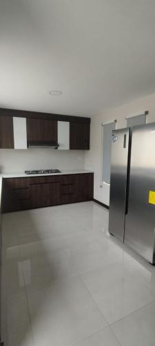 an empty kitchen with a stainless steel refrigerator at Casa 3 dormitorios J2 in Cuenca