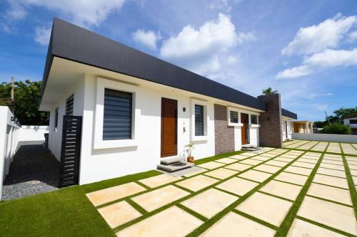 a house with a green lawn in front of it at Ramey Cir D, near airport, beaches W/KING Bed. in Aguadilla