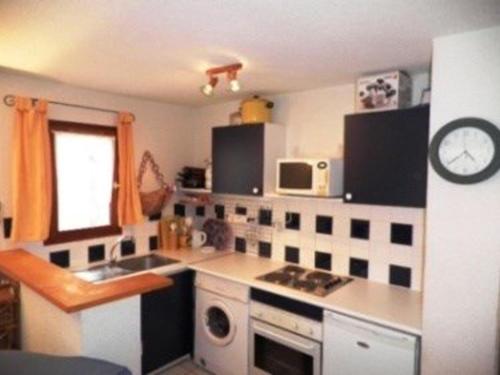 une cuisine avec un évier et une cuisinière four supérieur dans l'établissement Maison Climatisée 3 Pièces avec Piscine, Terrasse et Proche Mer - Gruissan - FR-1-229-822, à Gruissan