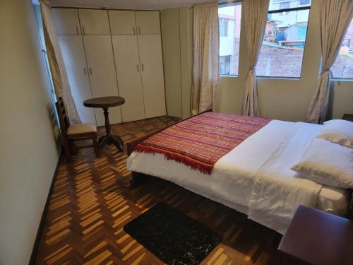 um quarto com uma cama grande e uma janela em Hermoso Departamento Central Familiar Tu Refugio con Impresionantes Vistas a la Ciudad, Montañas y Nevados em Riobamba