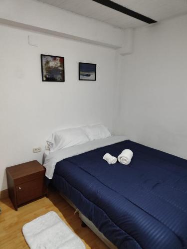 una camera da letto con un letto blu e asciugamani di Cómodo estudio vía termales a Santa Rosa de Cabal