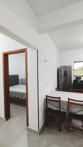 a room with a mirror and a table and a bed at Suítes do Vale - Praia do Rosa in Imbituba