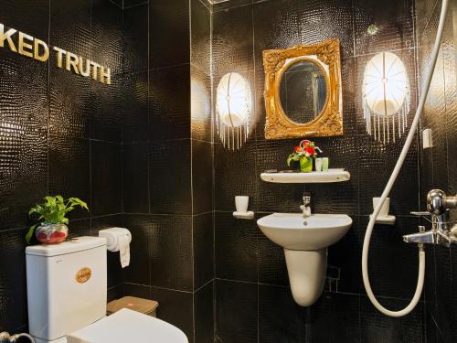 a bathroom with a sink and a toilet and a mirror at Thang Long Espana Hotel in Hanoi