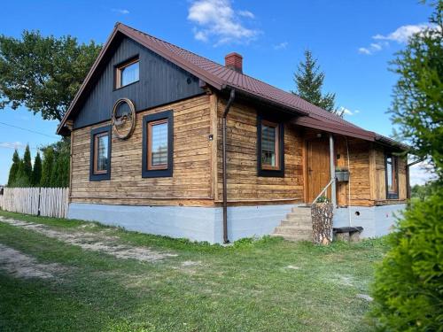 a small wooden house with a red roof at Dom Na Wsi in Mierzwin Duży
