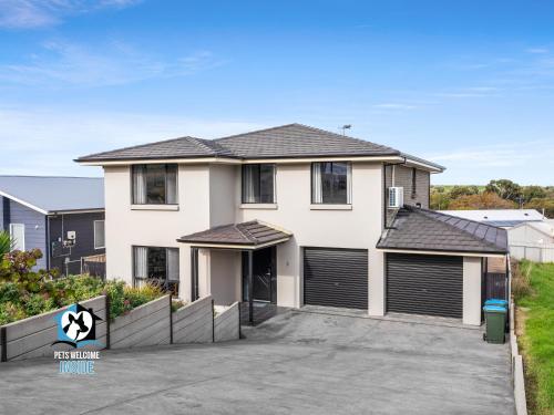 a large white house with two garage doors at Big House with Views and Fab Pop Culture Vibe in Encounter Bay