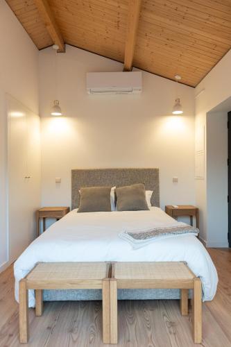 a bedroom with a large bed and a wooden ceiling at Quinta da Ribeirinha - Douro River in Paços de Gaiolo