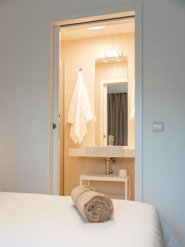 a bathroom with a bed and a sink and a mirror at Quinta da Ribeirinha - Douro River in Paços de Gaiolo