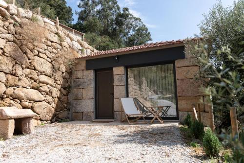 a building with a chair and a table in front of it at Quinta da Ribeirinha - Douro River in Paços de Gaiolo