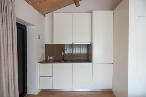 a kitchen with white cabinets and a sink at Quinta da Ribeirinha - Douro River in Paços de Gaiolo