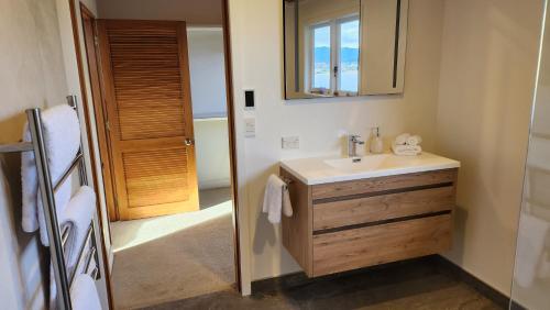 a bathroom with a sink and a mirror at The Black Chalet in Whitianga