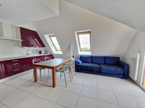 a living room with a blue couch and a table at Bel appartement T2 avec balcon, WIFI et parking près de la plage - FR-1-706-2 in Châtelaillon-Plage