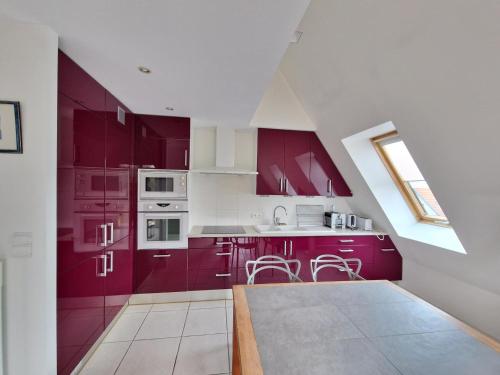 une cuisine avec des armoires rouges et des appareils blancs dans l'établissement Bel appartement T2 avec balcon, WIFI et parking près de la plage - FR-1-706-2, à Châtelaillon-Plage