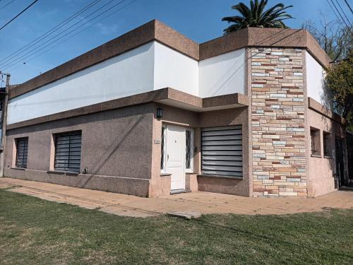 a small brick house with a white door at La Casa del Colibrí in San Pedro