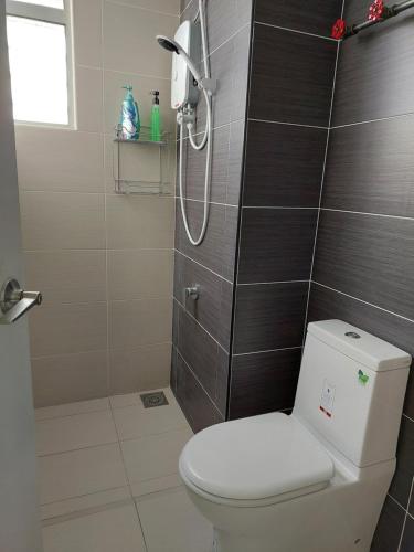 a bathroom with a white toilet and a shower at Manhattan Mount Austin Dekasa Homestay in Johor Bahru