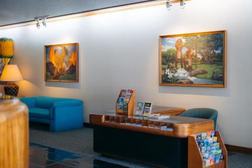 a waiting room with a blue couch and a painting on the wall at Ilima Hotel in Honolulu