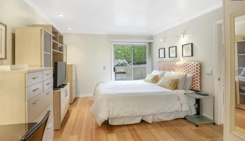 a white bedroom with a bed and a television at Monarch Beach - Gated Community - 1 Bed King in Dana Point