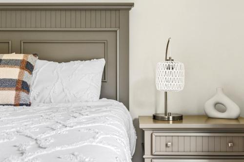 a bedroom with a bed and a lamp on a night stand at 13-Acre Private Estate, Private Lake, Private Golf Range, Private Forest & Hiking Trails in Ross Corner