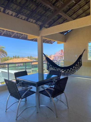 a patio with a table and chairs and a hammock at Casa do Mar Stella Maris in Salvador