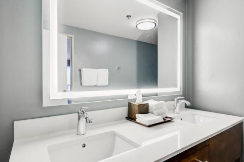 a bathroom with a white sink and a large mirror at Whitefish Riverfront Hotel in Whitefish
