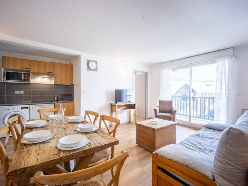 une cuisine et un salon avec une table et un canapé dans l'établissement Appartement 8 pers. Peyragudes avec piscine et proche des pistes - FR-1-695-27, à Germ