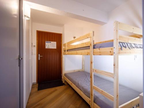 a bunk bed room with two bunk beds and a door at Appartement 8 pers. Peyragudes avec piscine et proche des pistes - FR-1-695-27 in Germ