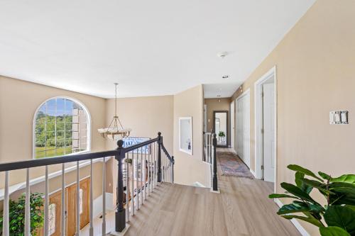 a staircase in a house with a hallway and a window at 13-Acre Private Estate, Private Lake, Private Golf Range, Private Forest & Hiking Trails in Ross Corner