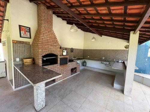een grote keuken met een bakstenen oven in de kamer bij Lindo sítio para você e sua família! in Guararema