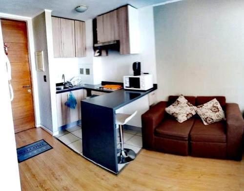 Apartament ten obejmuje kuchnię oraz salon z sofą i kuchenką mikrofalową. w obiekcie Lindo Departamento Amoblado (Cercano a terminal Sur y Aeropuerto) w mieście Santiago