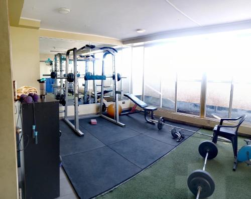 a gym with treadmills and equipment in a building at Departamento equipado (Cercano a terminal Sur y aeropuerto) in Santiago