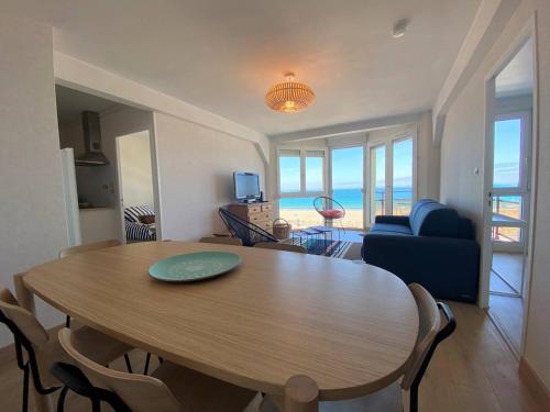 un salon avec une table et des chaises et l'océan dans l'établissement Appartement avec WIFI et Vue Mer, Plage de Trestraou à Perros-Guirec - FR-1-368-384, à Perros-Guirec