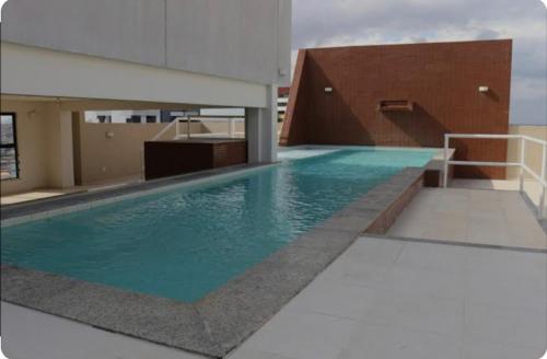 a swimming pool on the roof of a building at Loft no Condomínio Celita Franca Executive ApartHotel in Feira de Santana